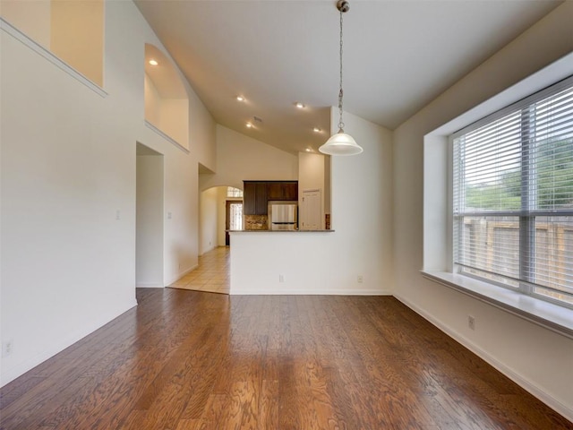 11600 Yeadon Way, Austin, TX 78717 - unfurnished living room featuring arched walkways, wood finished floors, high vaulted ceiling, and recessed lighting