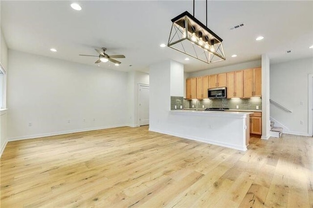 6800 Menchaca Rd Unit 45, Austin, TX 78745 - kitchen with stainless steel microwave, tasteful backsplash, recessed lighting, open floor plan, and light wood finished floors