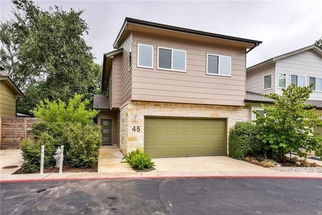 6800 Menchaca Rd Unit 45, Austin, TX 78745 - view of front of house with stone siding, a garage, and concrete driveway