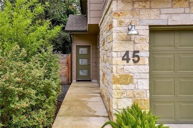 6800 Menchaca Rd Unit 45, Austin, TX 78745 - property entrance with stone siding, a garage, and roof with shingles