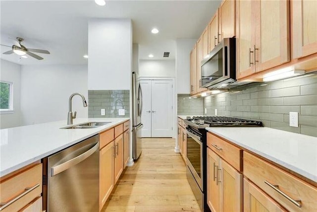 6800 Menchaca Rd Unit 45, Austin, TX 78745 - kitchen with stainless steel appliances, light wood-style flooring, a ceiling fan, light countertops, and backsplash