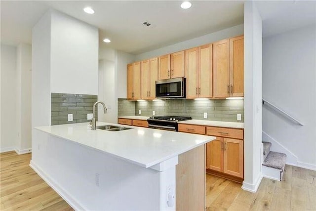 6800 Menchaca Rd Unit 45, Austin, TX 78745 - kitchen featuring stainless steel microwave, gas stove, light wood-style flooring, light countertops, and recessed lighting
