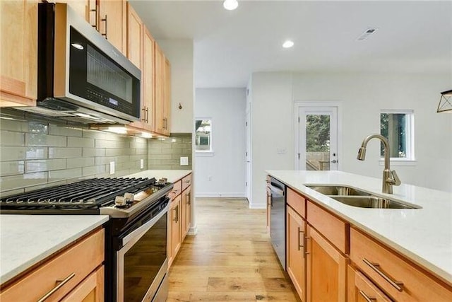 6800 Menchaca Rd Unit 45, Austin, TX 78745 - kitchen with stainless steel appliances, light wood-style floors, light countertops, backsplash, and recessed lighting
