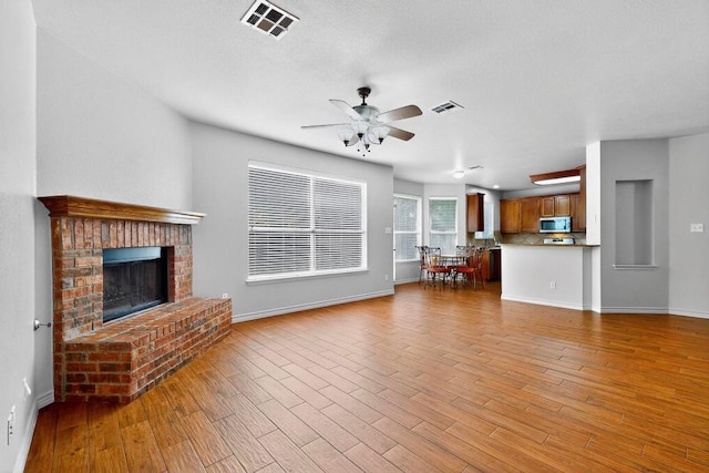1532 Homewood Cir, Round Rock, TX 78665 - unfurnished living room with a ceiling fan, wood finished floors, and a fireplace