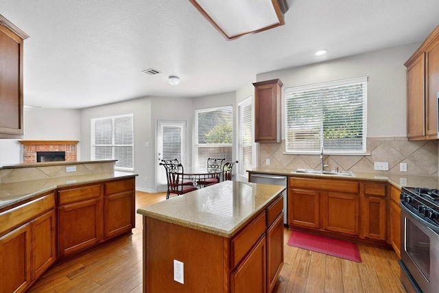 1532 Homewood Cir, Round Rock, TX 78665 - kitchen featuring appliances with stainless steel finishes, light wood-type flooring, backsplash, brown cabinetry, and recessed lighting