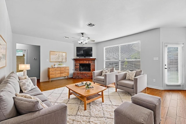 1532 Homewood Cir, Round Rock, TX 78665 - living area featuring plenty of natural light, light wood-style flooring, ceiling fan, and a brick fireplace