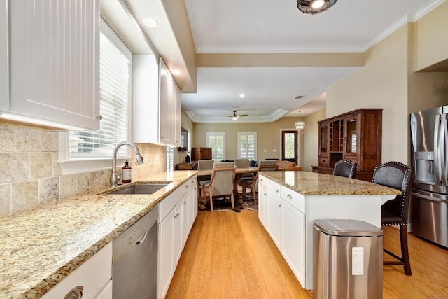 260 N Santa Clara Ave, New Braunfels, TX 78130 - kitchen with stainless steel appliances, light wood-style floors, plenty of natural light, white cabinets, and ornamental molding