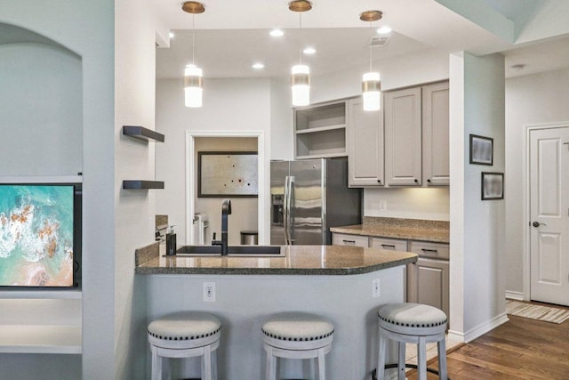 300 San Gabriel Village Blvd Unit 423, Georgetown, TX 78626 - kitchen with open shelves, stainless steel fridge with ice dispenser, a peninsula, dark wood-style flooring, and a breakfast bar
