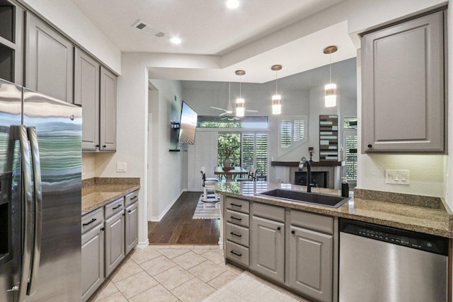 300 San Gabriel Village Blvd Unit 423, Georgetown, TX 78626 - kitchen featuring stainless steel appliances, gray cabinets, a peninsula, ceiling fan, and light tile patterned flooring