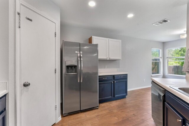 620 Lavaca Loop, Elgin, TX 78621 - kitchen featuring appliances with stainless steel finishes, light wood-style flooring, light countertops, white cabinetry, and recessed lighting