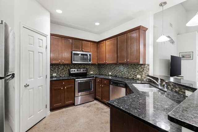 14601 Running Deer Trl, Austin, TX 78734 - kitchen featuring appliances with stainless steel finishes, dark stone countertops, tasteful backsplash, decorative light fixtures, and a peninsula