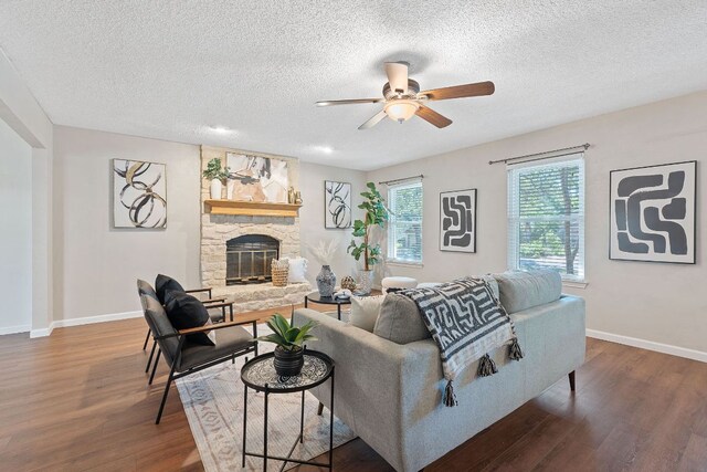 8206 Avocet Dr, Austin, TX 78745 - living room featuring ceiling fan, wood finished floors, a textured ceiling, and a stone fireplace