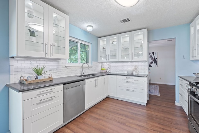 8206 Avocet Dr, Austin, TX 78745 - kitchen with appliances with stainless steel finishes, dark countertops, white cabinetry, and a textured ceiling