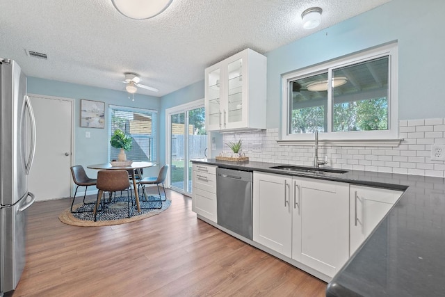 8206 Avocet Dr, Austin, TX 78745 - kitchen with stainless steel appliances, dark countertops, healthy amount of natural light, ceiling fan, and a textured ceiling
