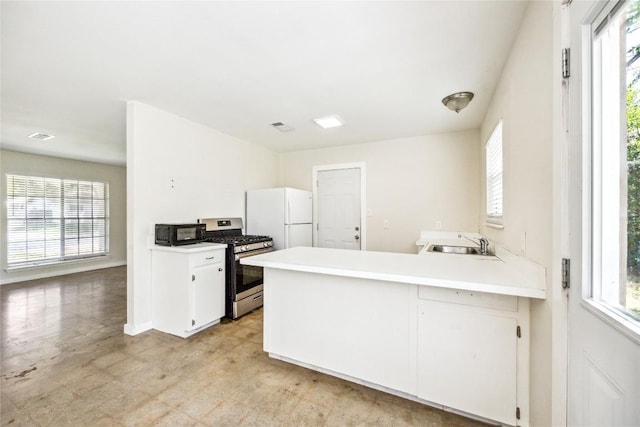 6907 Deborah Dr, Austin, TX 78752 - kitchen featuring freestanding refrigerator, stainless steel range with gas stovetop, plenty of natural light, and light countertops