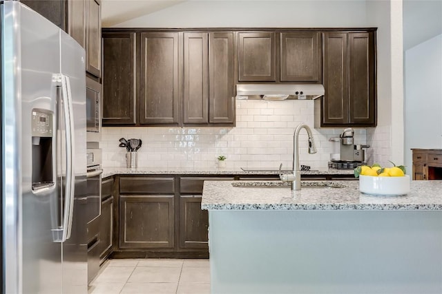 1901 Owens Ln, Lago Vista, TX 78645 - kitchen with appliances with stainless steel finishes, dark brown cabinetry, backsplash, light tile patterned floors, and lofted ceiling