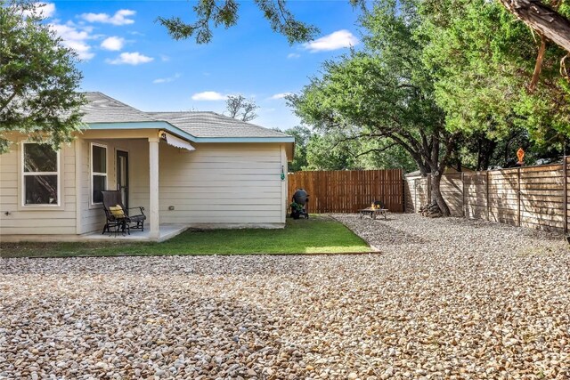 1901 Owens Ln, Lago Vista, TX 78645 - back of house featuring a fenced backyard, a patio area, and roof with shingles