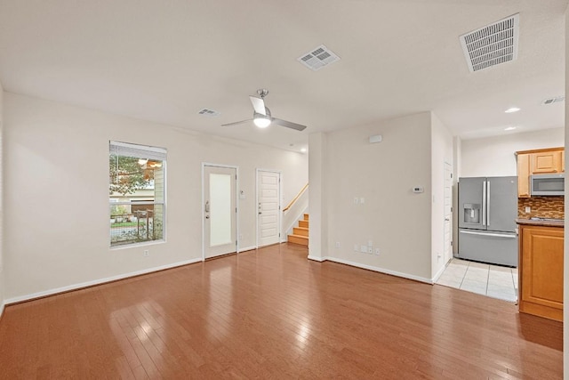 1900 Tramson Dr Unit 94C, Austin, TX 78741 - unfurnished living room with a ceiling fan, light wood-type flooring, and stairway
