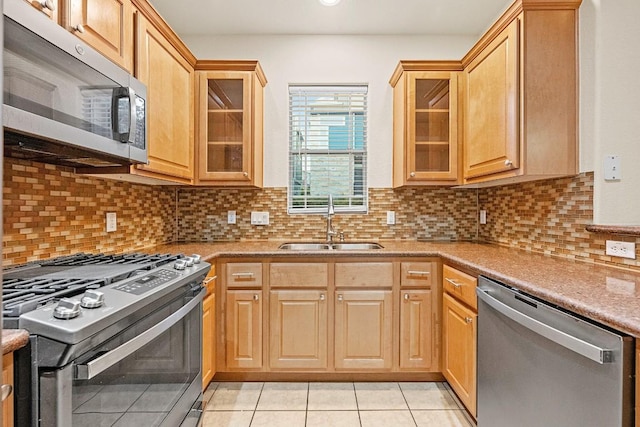 1900 Tramson Dr Unit 94C, Austin, TX 78741 - kitchen featuring appliances with stainless steel finishes, light tile patterned flooring, glass insert cabinets, decorative backsplash, and recessed lighting