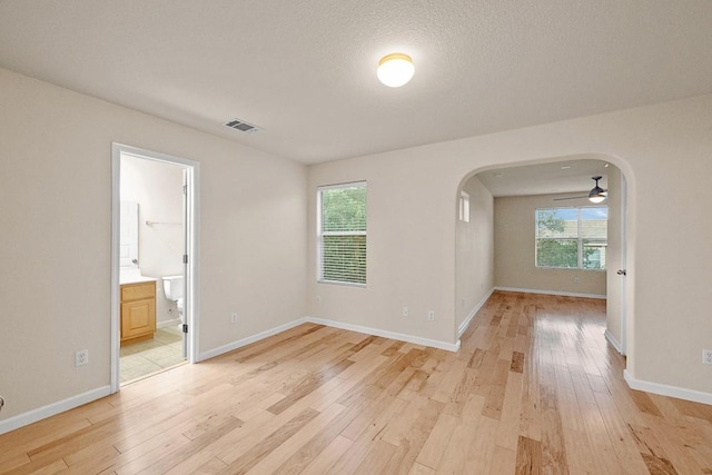 1900 Tramson Dr Unit 94C, Austin, TX 78741 - unfurnished room featuring arched walkways, light wood finished floors, and healthy amount of natural light