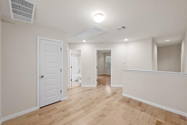 1900 Tramson Dr Unit 94C, Austin, TX 78741 - empty room with attic access, light wood-style flooring, recessed lighting, and a textured ceiling