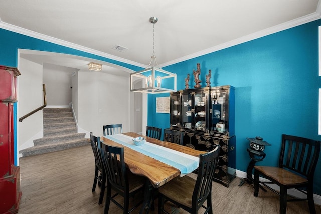 15913 Villa Frontera Dr, Bee Cave, TX 78738 - dining space featuring crown molding, stairs, wood finished floors, a chandelier, and arched walkways