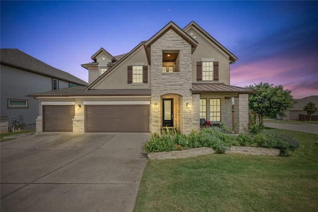 15913 Villa Frontera Dr, Bee Cave, TX 78738 - view of front facade featuring driveway, stone siding, a yard, a standing seam roof, and stucco siding