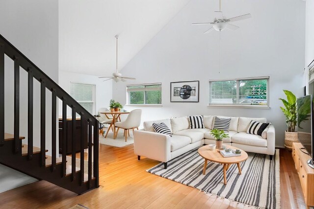 1917 Miles Ave, Austin, TX 78745 - living room with a ceiling fan, high vaulted ceiling, light wood finished floors, and stairway