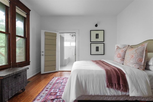 1917 Miles Ave, Austin, TX 78745 - bedroom featuring radiator heating unit, wood finished floors, and ensuite bathroom