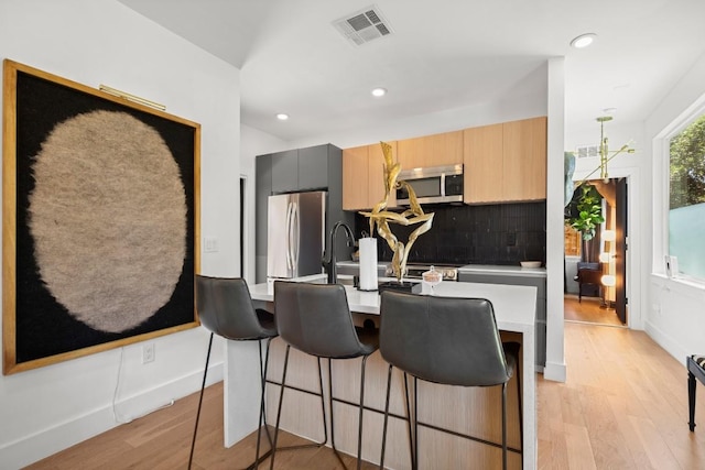 4802 Gladeview Dr Unit 2, Austin, TX 78745 - kitchen featuring appliances with stainless steel finishes, light wood finished floors, light countertops, backsplash, and recessed lighting