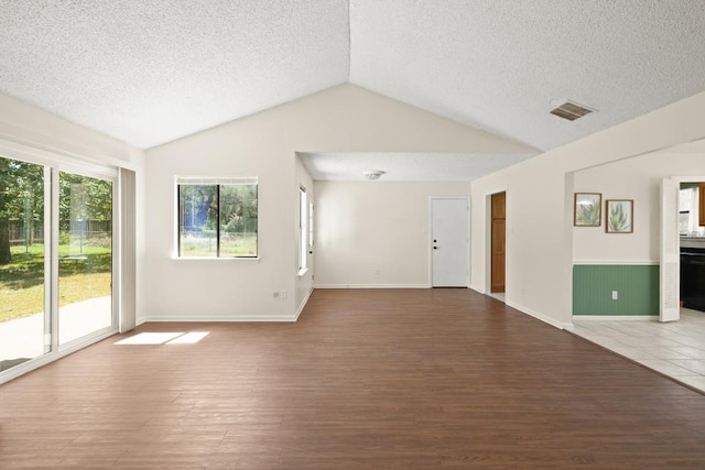 132 Spanish Oak Dr, Georgetown, TX 78628 - unfurnished living room with wood finished floors, a textured ceiling, and vaulted ceiling