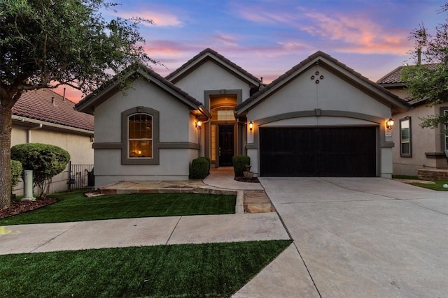 9110 Bayshore Bnd Unit 30, Austin, TX 78726 - view of front of home featuring an attached garage, concrete driveway, stucco siding, and a front yard