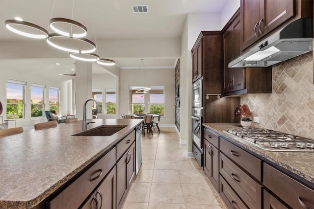 9110 Bayshore Bnd Unit 30, Austin, TX 78726 - kitchen featuring appliances with stainless steel finishes, under cabinet range hood, plenty of natural light, tasteful backsplash, and ornamental molding