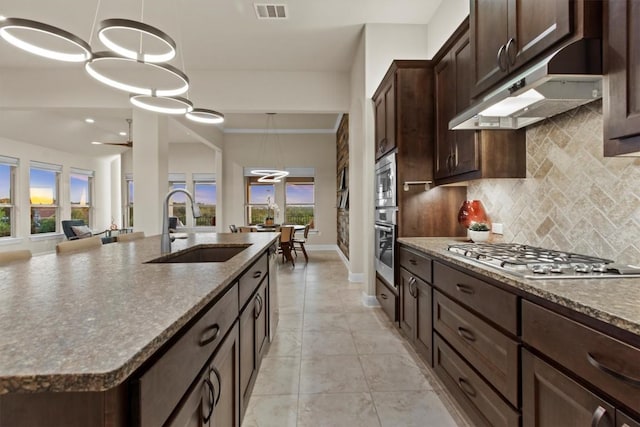 9110 Bayshore Bnd Unit 30, Austin, TX 78726 - kitchen featuring appliances with stainless steel finishes, under cabinet range hood, healthy amount of natural light, backsplash, and recessed lighting