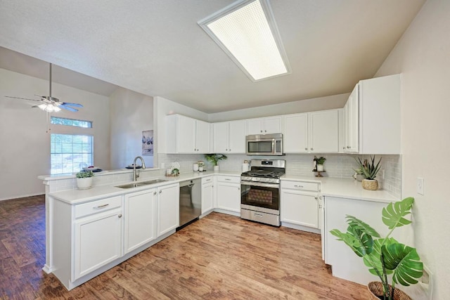 1803 Kwai Cv, Leander, TX 78641 - kitchen with stainless steel appliances, tasteful backsplash, vaulted ceiling, light wood-style floors, and white cabinets