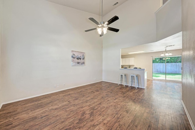 1803 Kwai Cv, Leander, TX 78641 - unfurnished room with dark wood-type flooring, a chandelier, a ceiling fan, and a high ceiling