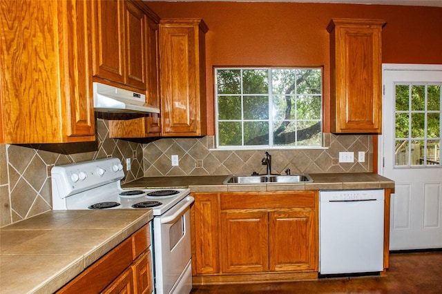2003 White Dove Pass, Austin, TX 78734 - kitchen with white appliances, under cabinet range hood, brown cabinetry, and backsplash