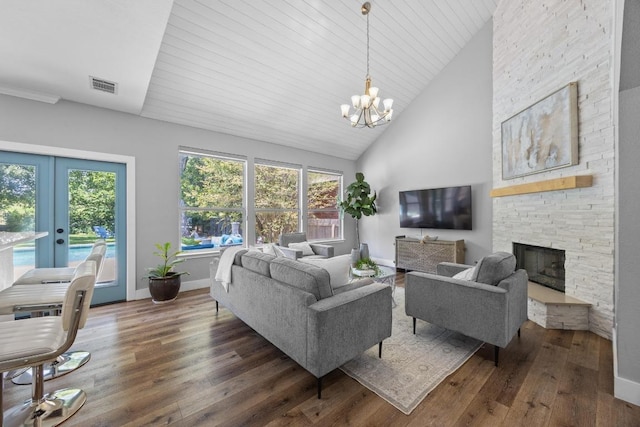 15001 Doria Dr, Austin, TX 78728 - living area featuring wood-type flooring, a chandelier, french doors, a stone fireplace, and high vaulted ceiling