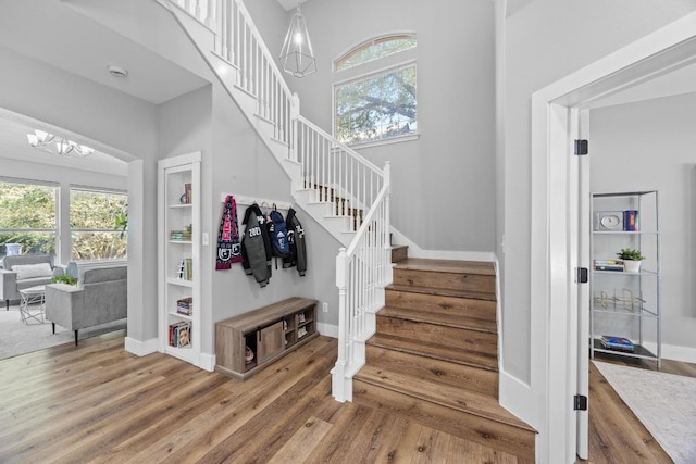 15001 Doria Dr, Austin, TX 78728 - stairs featuring plenty of natural light, wood finished floors, and a chandelier