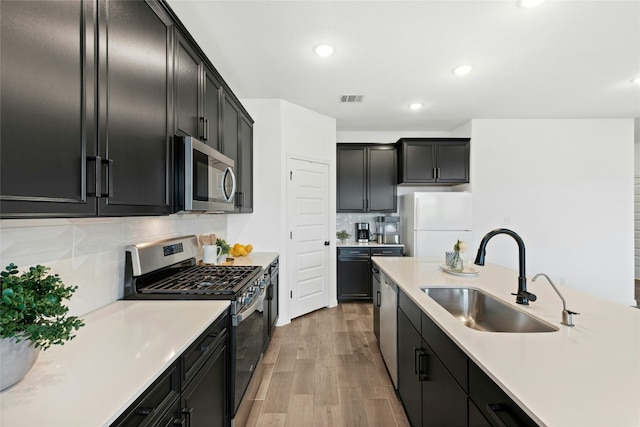 2616 Danbury Ln, Leander, TX 78641 - kitchen featuring appliances with stainless steel finishes, dark cabinets, light countertops, and recessed lighting