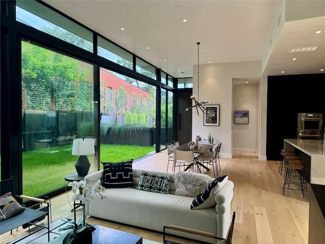 1315 W 9th St Unit B, Austin, TX 78703 - living area with floor to ceiling windows, light wood-type flooring, a chandelier, and recessed lighting