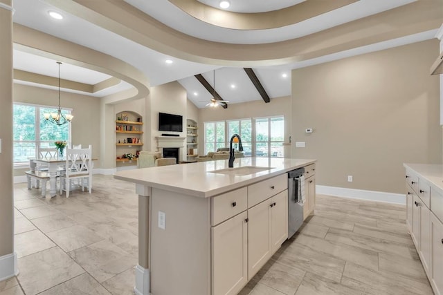 101 Dorado St, Georgetown, TX 78628 - kitchen with light marble finish flooring, built in shelves, a fireplace, stainless steel dishwasher, and light countertops