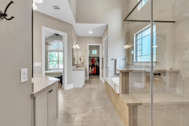 101 Dorado St, Georgetown, TX 78628 - ensuite bathroom with a stall shower, a bath, vanity, tile patterned flooring, and a walk in closet