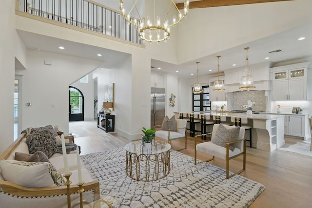 6905 Rudi Cv, Austin, TX 78759 - living room featuring light wood-style flooring, a high ceiling, a chandelier, and recessed lighting