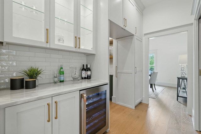 6905 Rudi Cv, Austin, TX 78759 - indoor dry bar featuring wine cooler, light wood-style flooring, and decorative backsplash
