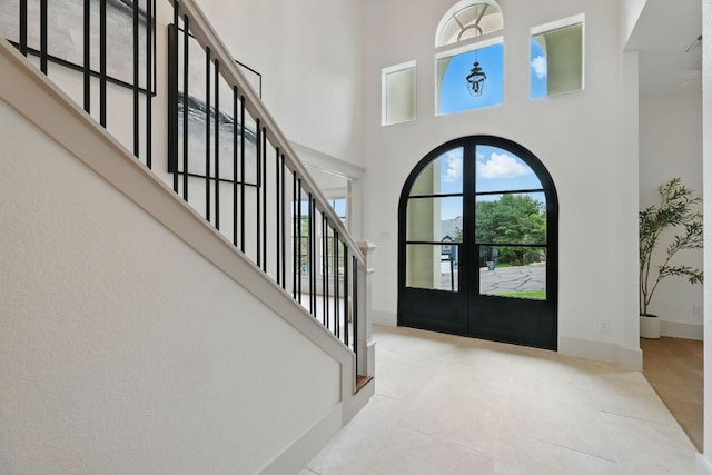 6905 Rudi Cv, Austin, TX 78759 - entrance foyer featuring a high ceiling, french doors, tile patterned floors, and stairway