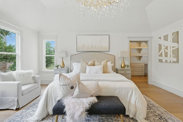 6905 Rudi Cv, Austin, TX 78759 - bedroom with lofted ceiling, a chandelier, and light wood finished floors