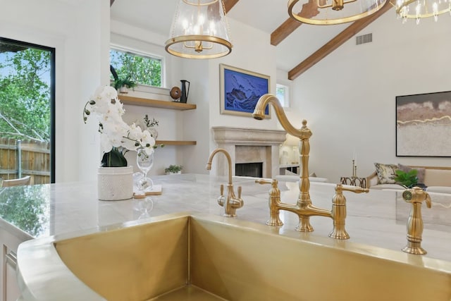 6905 Rudi Cv, Austin, TX 78759 - kitchen with a chandelier, open shelves, a fireplace, and light stone countertops