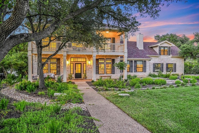 3342 Far View Dr, Austin, TX 78730 - view of front of home with a balcony, stone siding, a yard, and a chimney