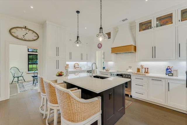 3342 Far View Dr, Austin, TX 78730 - kitchen featuring custom exhaust hood, stainless steel range with electric cooktop, white cabinetry, light countertops, and a kitchen island with sink